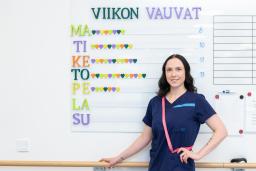 Lähihoitaja Christa Ekfors seisoo Jorvin sairaalan syntyneistä vauvoista kertovan taulun edessä.