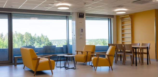 aulatila, jossa sohvia, tuoleja ja pöytiä, taustalla isot ikkunat, katossa led-valaistus, ilmanvaihtoluukkuja