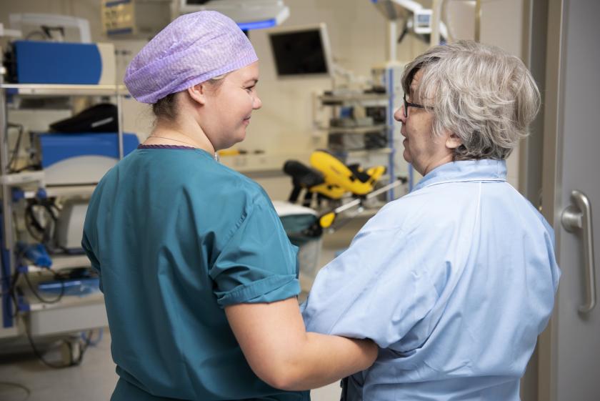 Kuvituskuva: Sairaanhoitaja taluttaa potilasta leikkaussaliin