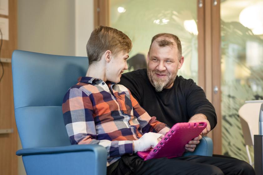 Isä ja poika sairaalan aulassa