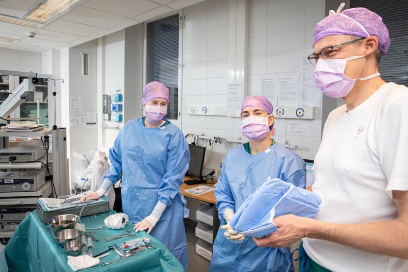 Kuvituskuva: lääkärit ja hoitajat valmistautumassa leikkaukseen