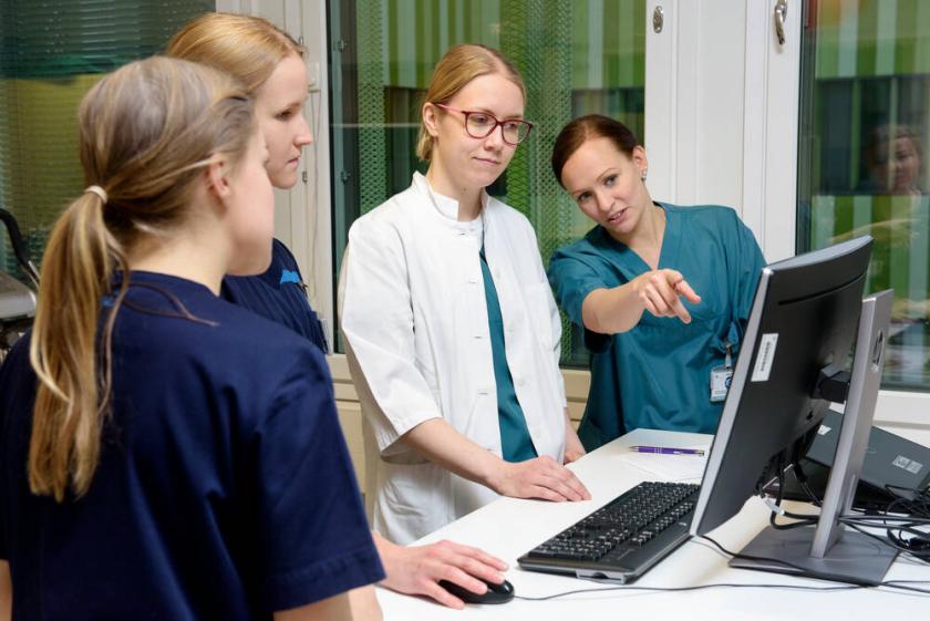 Lääkärit ja hoitajat katsomassa tietokoneen näyttöä