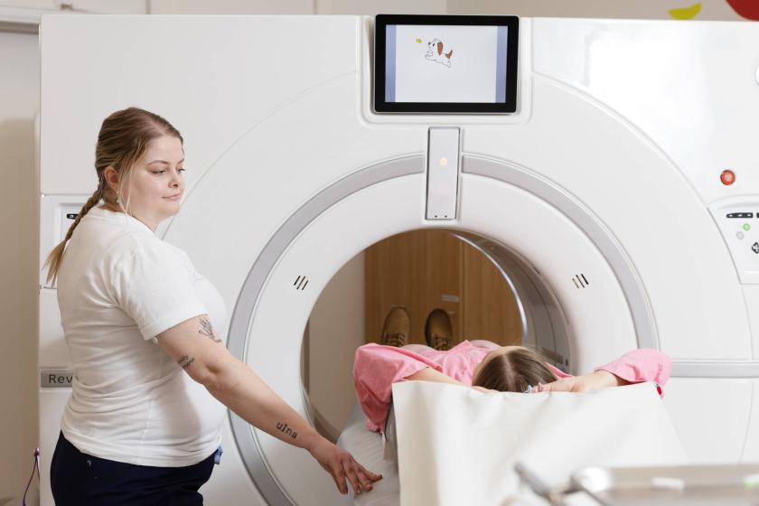 A ragiographer placing a patient in an MRI machine.