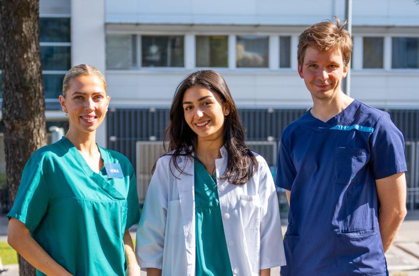 Tre leende HUS sommarjobbare bredvid varandra ute i solen