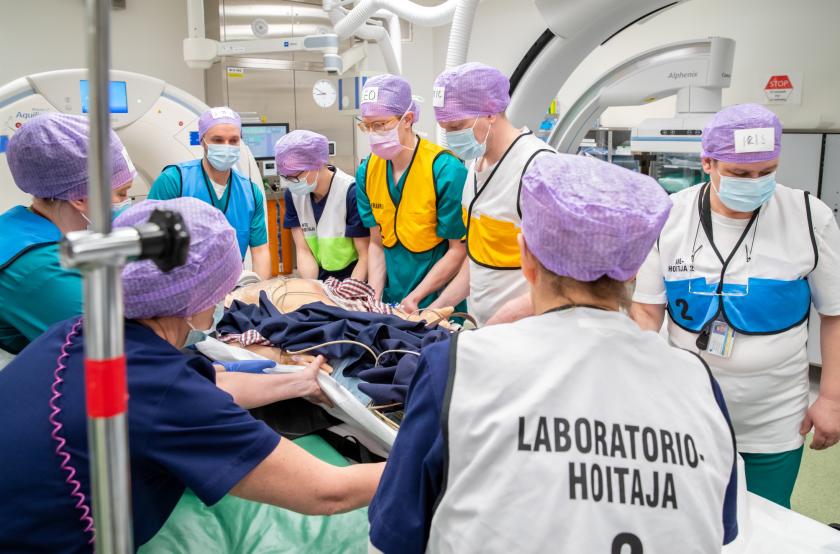 Simulaatiotilanne, useita ammattilaisia simulaattorin ympärillä.