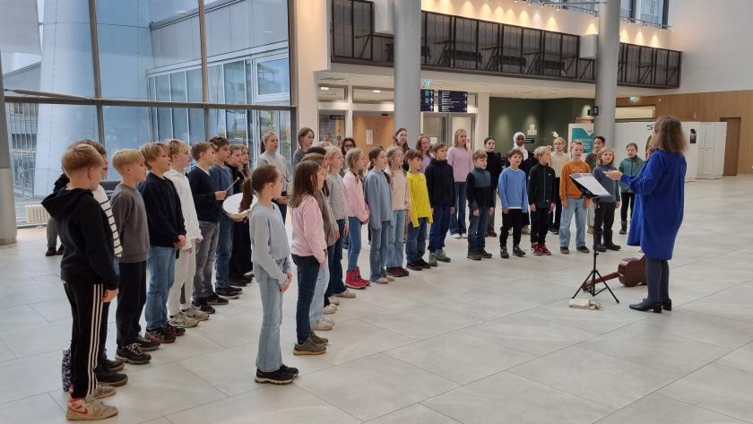 Lapsikuoro esiintymässä sairaalan aulassa.