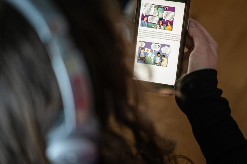 En person håller en mobil med en app för digital rehabilitering.