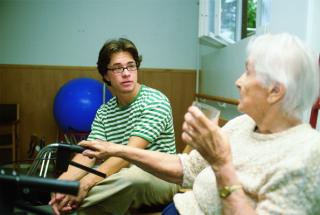Lähihoitaja keskustelee vanhuksen kanssa.