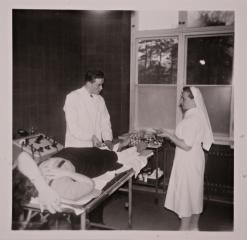 Potilasta hoidetaan Suomen Punaisen Ristin sairaalan päivystyksen toimenpidehuoneessa 1940- tai 1950-luvulla.