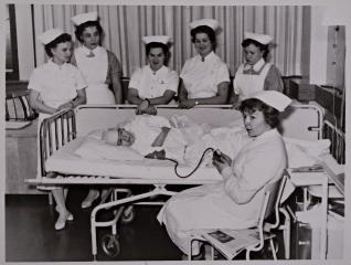Kuvassa hoitaja tarkkailee potilaan tilaa sängyn vieressä Suomen ensimmäisellä tehosteisen valvonnan osastolla.