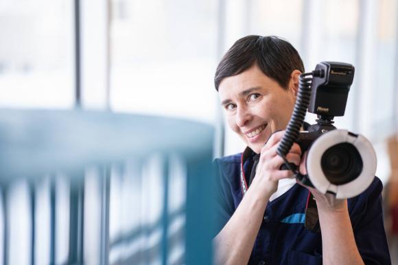 Valokuvaaja Aino Huovio-Airaksinen kamera kädessään.