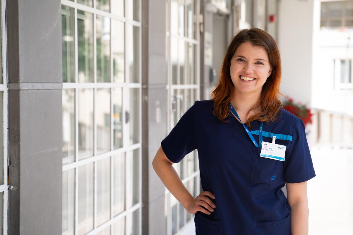 Kätilöopiskelija Nita Ramponen seisoo ja hymyilee ulkona kesällä.