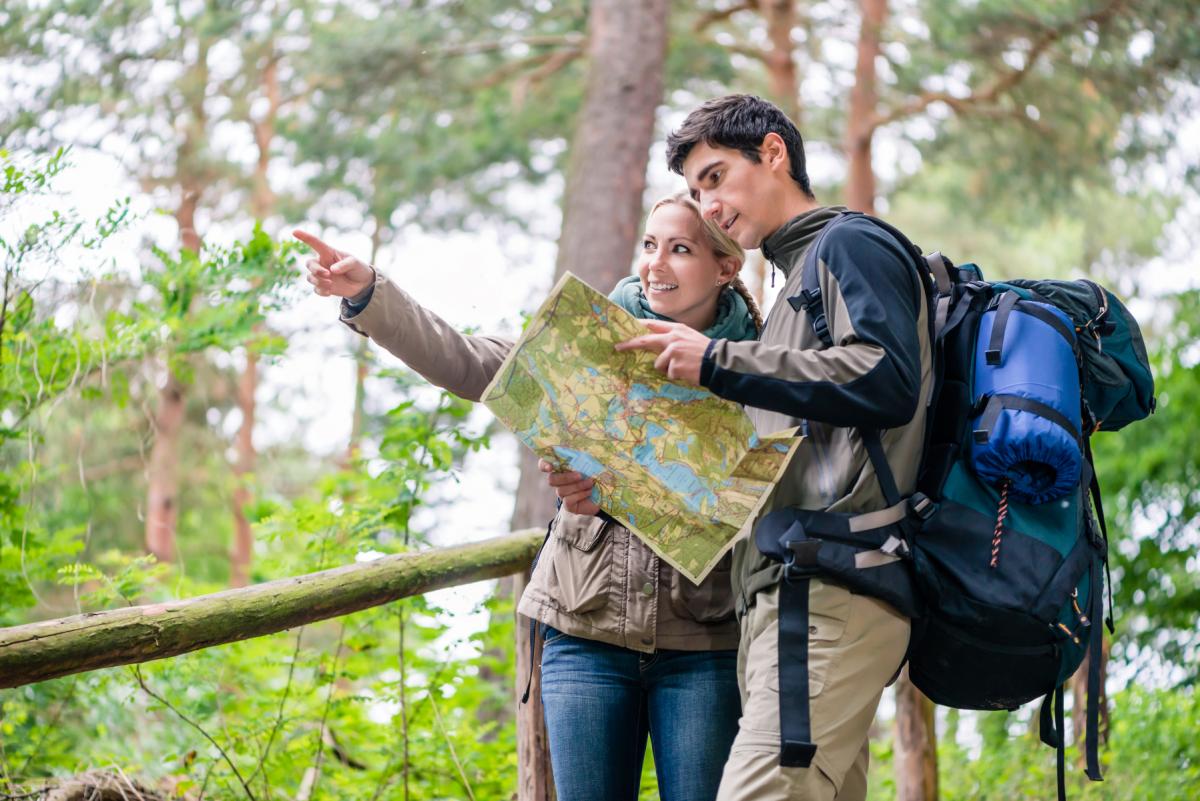 Woman and man explore a map in the nature.