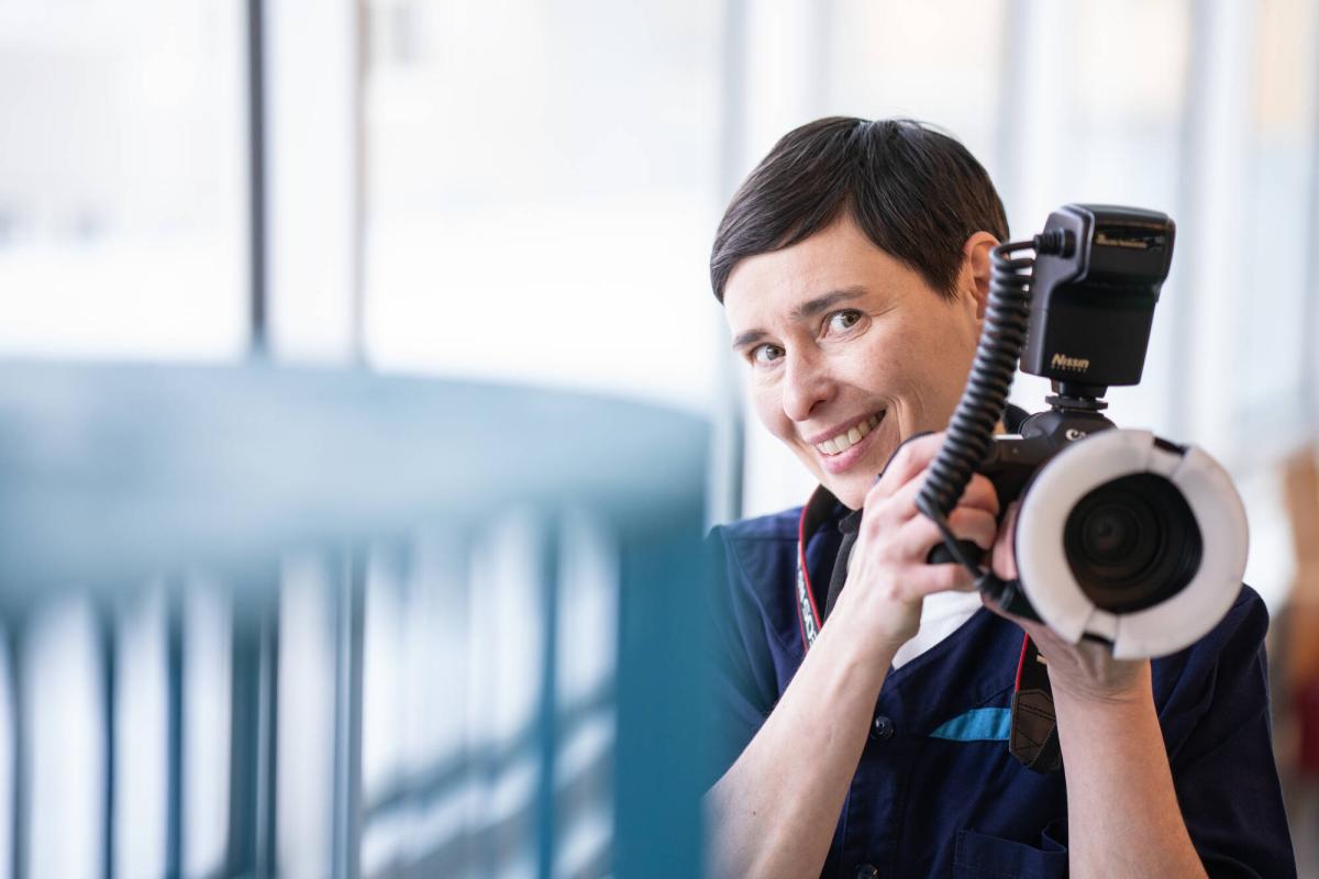 Valokuvaaja Aino Huovio-Airaksinen kamera kädessään.