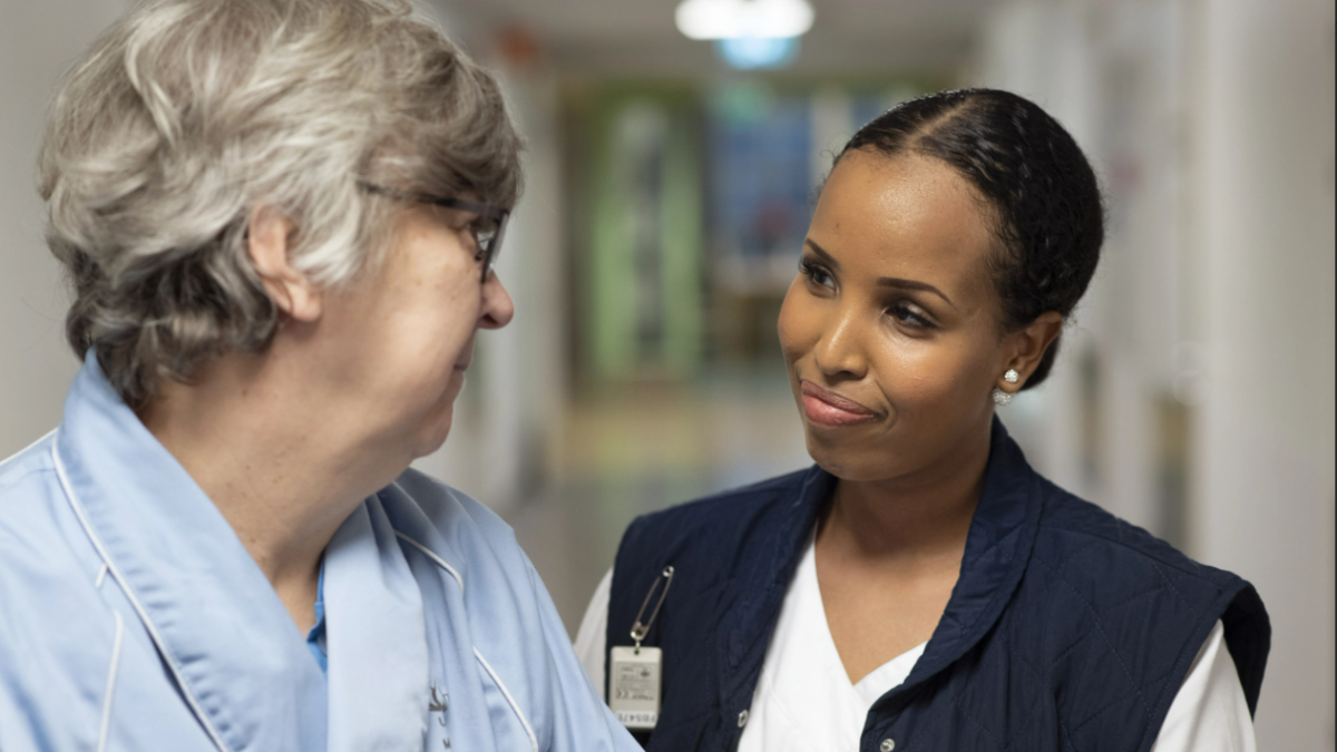 Potilaan ja hoitohenkilöstöön kuuluvan katsekontakti käytävällä.