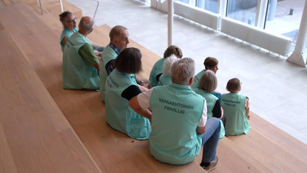 OLKA-toiminnan vapaaehtoisia istumassa Siltasairaalan portailla