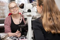two pathologists in front of a microscope