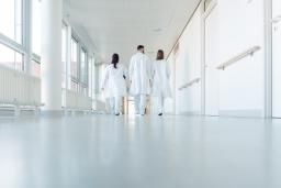 Sairaalan käytävää kävelee kolme lääkäriä