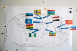 Seinällä on maailmankartta, johon on liimattu lappuja. Lappuihin on kirjoitettu työntekijöiden lähtömaat.