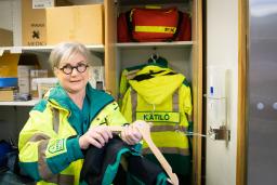 Kätilö Marjut Heikintalo pukee päälleen ambulanssityössä tarvittavia vaatteita.