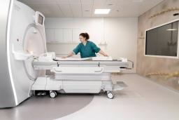A nurse is preparing a PET-MRI-machine.