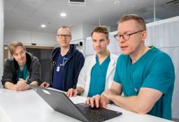 terveydenhuollon henkilöitä kannettavan tietokoneen kanssa sairaalan tiskillä