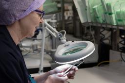 Välinehuoltaja tarkistaa instrumenttia.