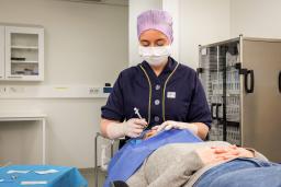 Hoitaja antaa silmän pistoshoitoa potilaalle