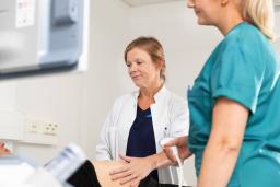 Lääkäri ja hoitaja tutkivat raskaana olevaa potilasta.