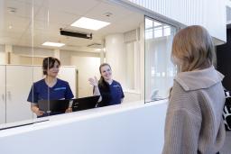 aulapalvelussa kaksi naistyöntekijää ohjaa naisasiakasta oikeaan suuntaan