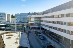 sairaalan julkisivu, josta pääovi erottuu selkeästi, rakennuksen yläkulmassa HUSin logo 