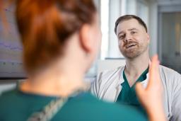 Gynekologi Otto Forsbom keskustelee selin kameraan olevan hoitajan kanssa.