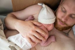 Vastasyntynyt vauva makaa ihokontaktissa vanhempansa sylissä.