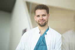 Lääkäri Ilari Rautalin valkoisessa takissa ja vihreässä paidassa.