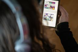 En person håller en mobil med en app för digital rehabilitering.