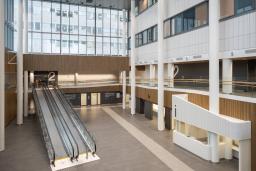 Ny huvudentréhall i Jorvs sjukhus med ljus interiör, rullramp och informationsdisk.